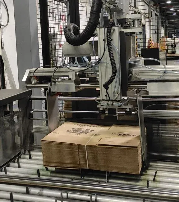 Máquina industrial apilando cajas de cartón embaladas