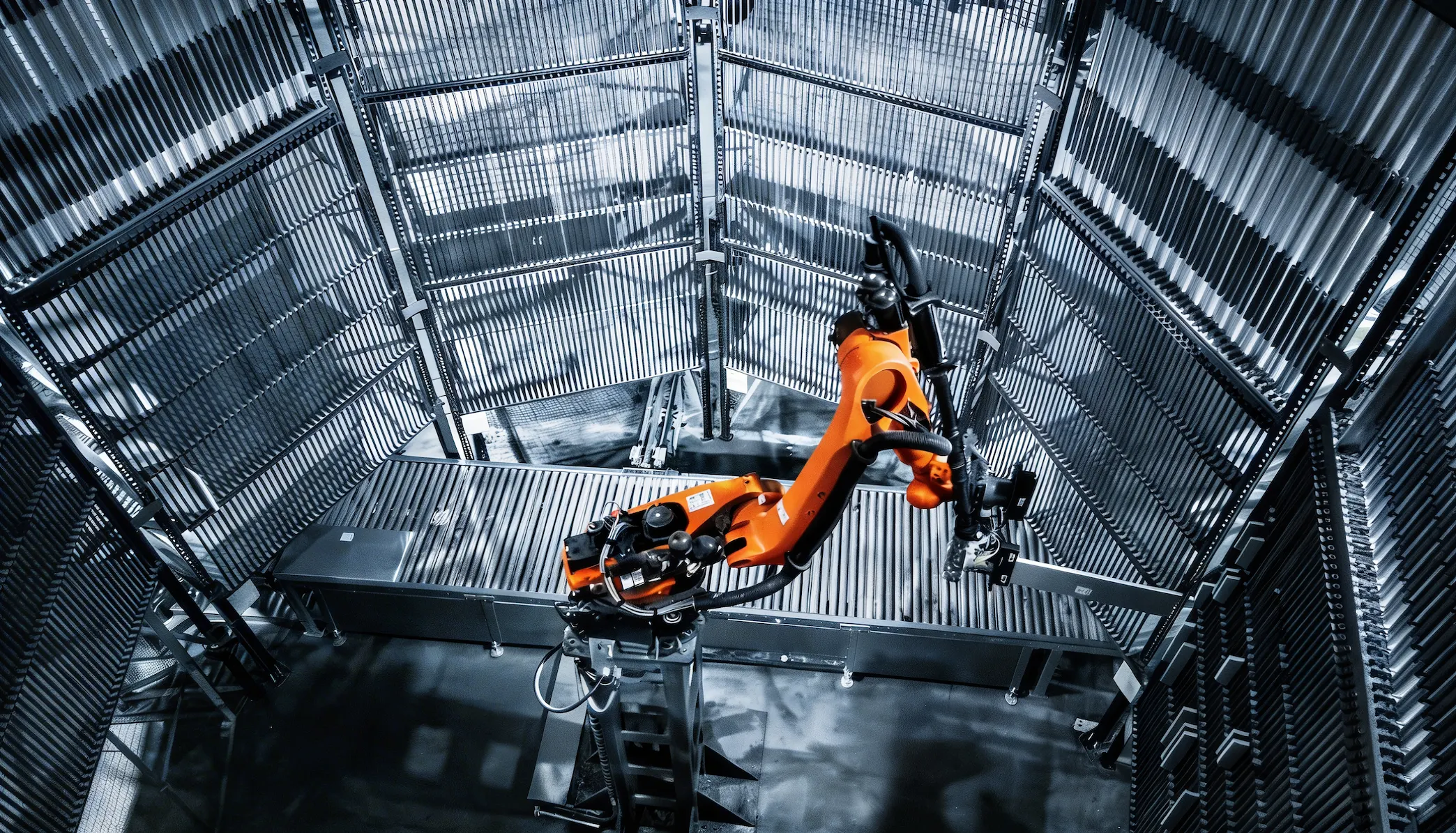 Brazo robótico naranja en una instalación industrial metálica